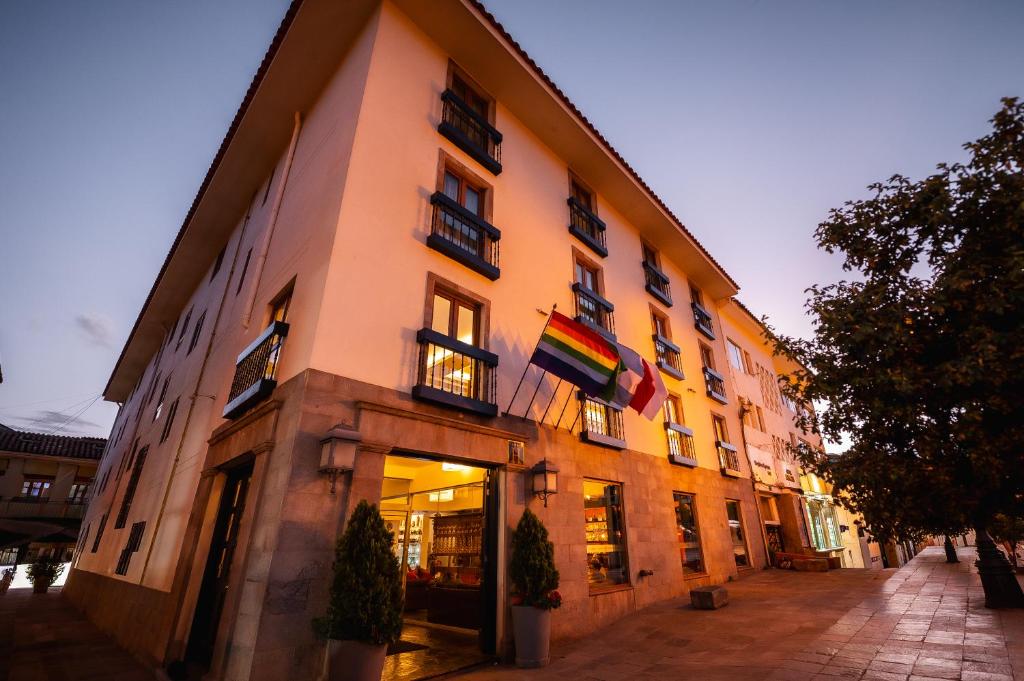 a building with flags on the side of it at San Agustin Plaza in Cusco