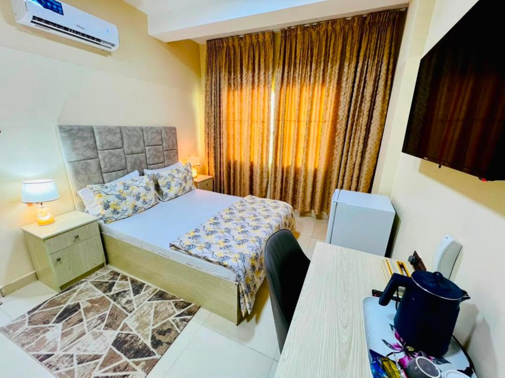 a bedroom with a bed and a desk and a television at mudha hotel in Hargeysa