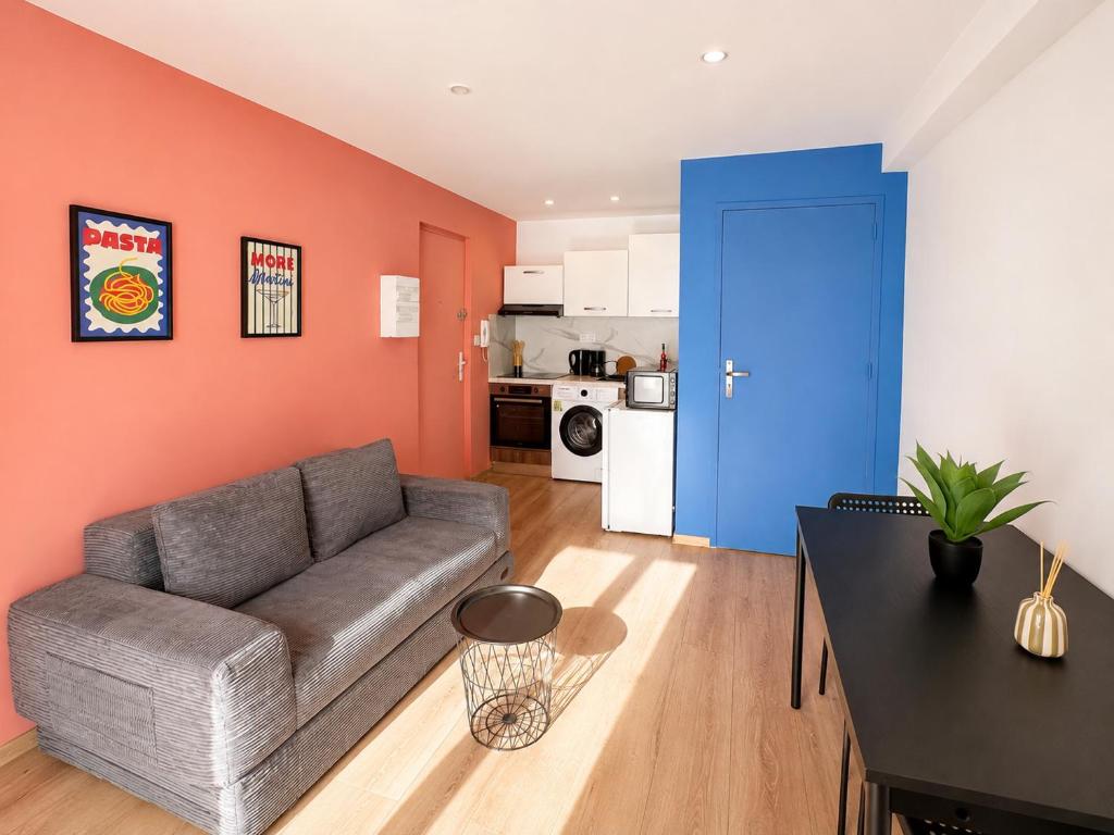 a living room with a couch and a blue door at Le Nid de MIMI in Bollène