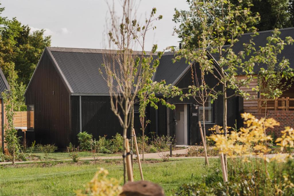 a black house with a tree in the yard at Adam in Marlborough