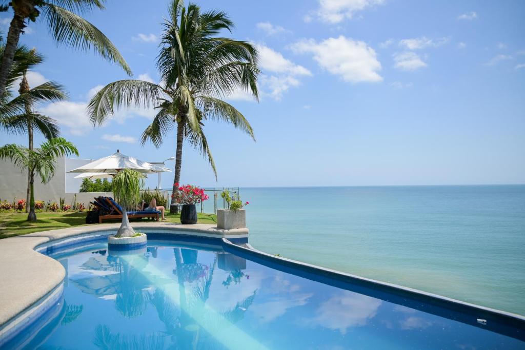 a swimming pool with the ocean in the background at Hotel Vistalmar in Manta