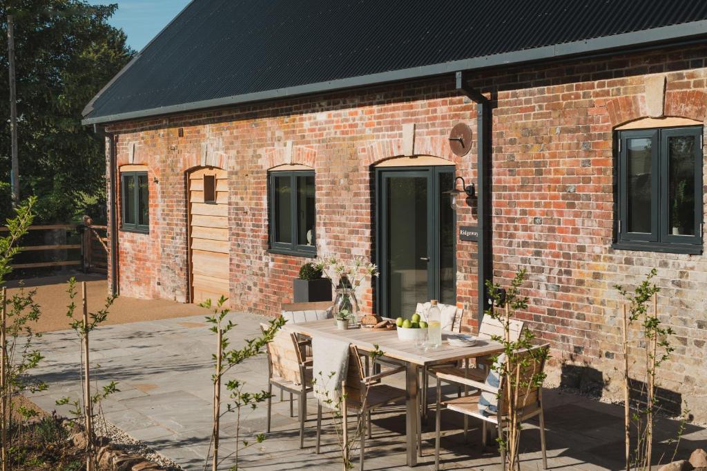 a patio with a table and chairs in front of a brick building at Ridgeway in Marlborough