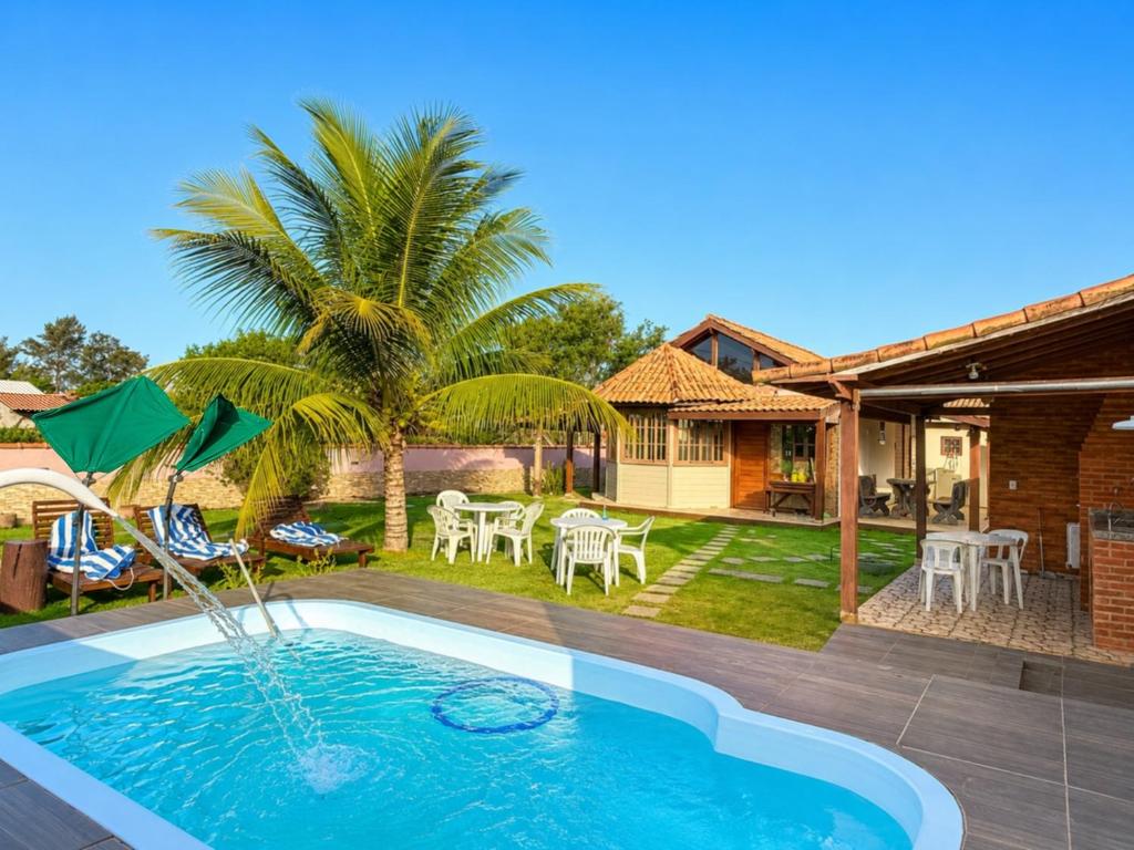 a backyard with a swimming pool and a house at Meu Refúgio Praia Seca in Araruama