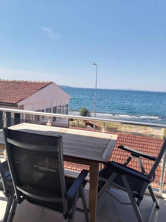 a table and chairs on a balcony with the ocean at Urla Sea View House in Urla