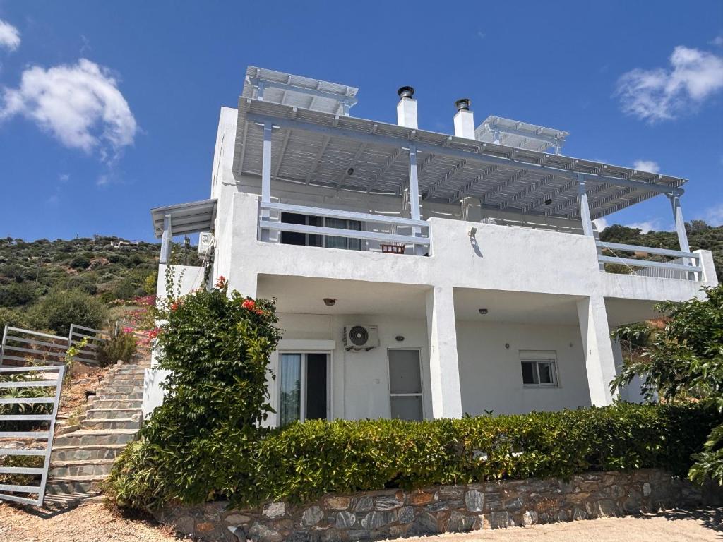 a white house with a balcony on top of it at Agnanti in Akhladherí