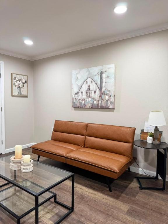 a living room with a brown couch and a table at The Sandstone Suite in Cleveland