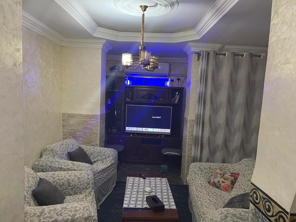 a living room with two chairs and a television at Chimino in Sétif