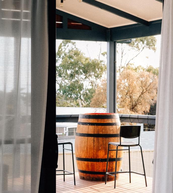 a barrel sitting on a porch with two chairs at Seascape Cottage on Kangaroo Island in Baudin Beach