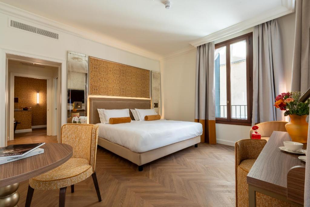 a hotel room with a bed and a table at Hotel San Samuele in Venice