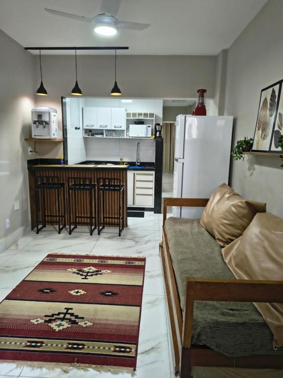 a kitchen and living room with a couch and a refrigerator at Castanheiras,perto de tudo,Internet,cadeiras,cooler e guarda sol in Guarapari