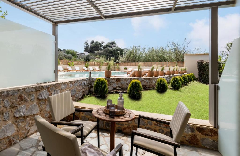 a patio with a table and chairs and a pool at Astoria Hotel in Troulos
