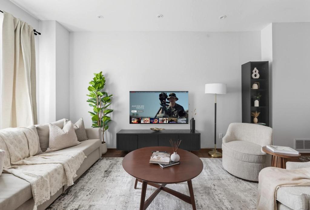 a living room with a couch and a tv on a wall at Stylish 4BR Toronto House Backyard Dinners in Toronto