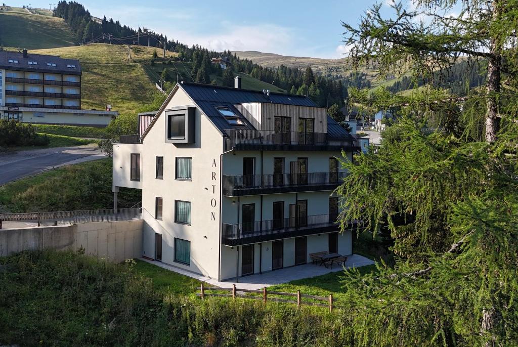 a white house with a black roof at Arton Lachtal - Apartments Steiermark in Lachtal