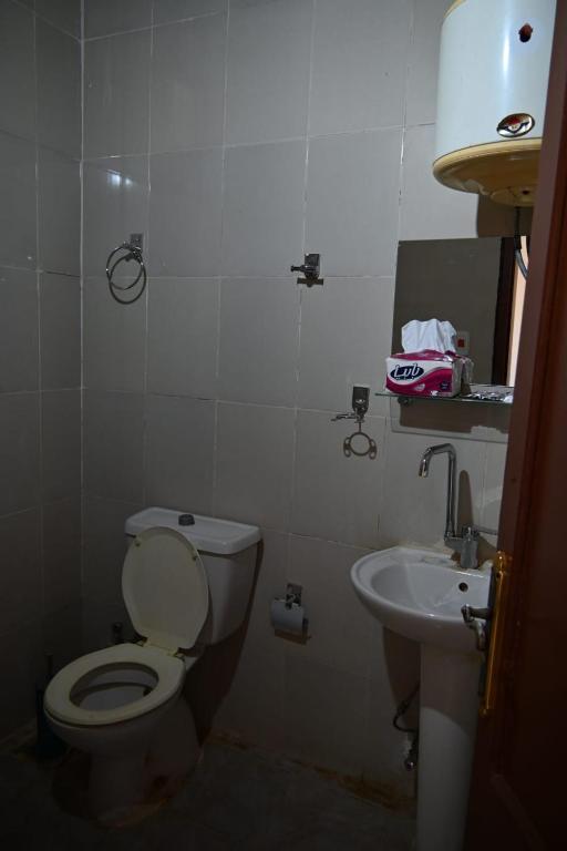a small bathroom with a toilet and a sink at شقة رويال سويت in Abu Simbel