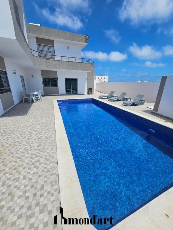 a swimming pool in front of a house at Sablette mostaganem in Les Sablettes Mazagran-Plage
