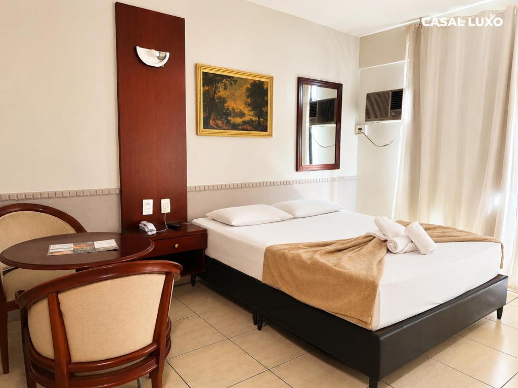 a hotel room with a bed and a table and a desk at Hotel Alvorada Taguatinga by Bsb Inn in Taguatinga