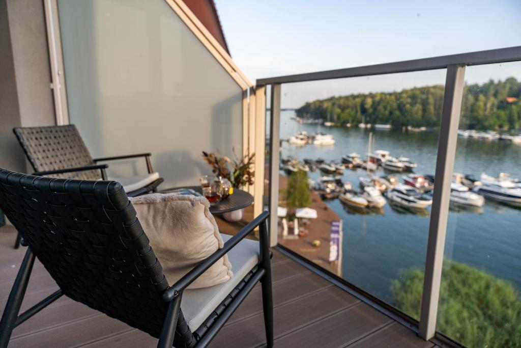 a balcony with chairs and a view of a marina at Lake Rental Inpro 89 in Mikołajki