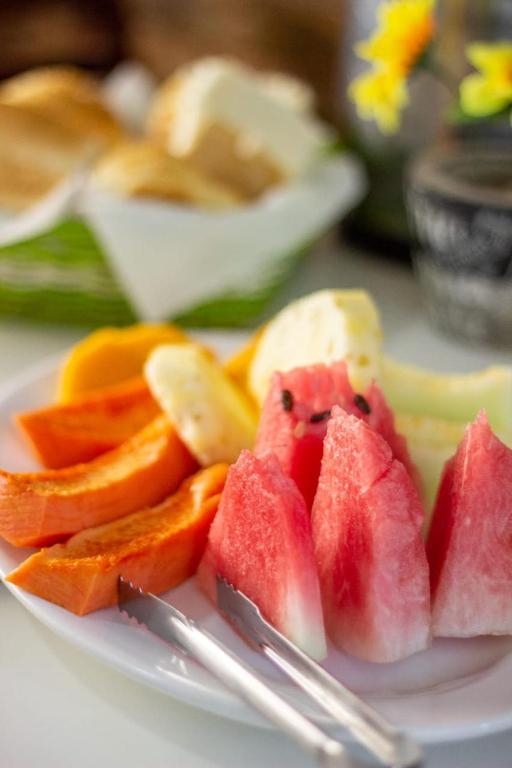 a plate with slices of fruit on a table at Pajuçara Inn - Pousada Maceió in Maceió