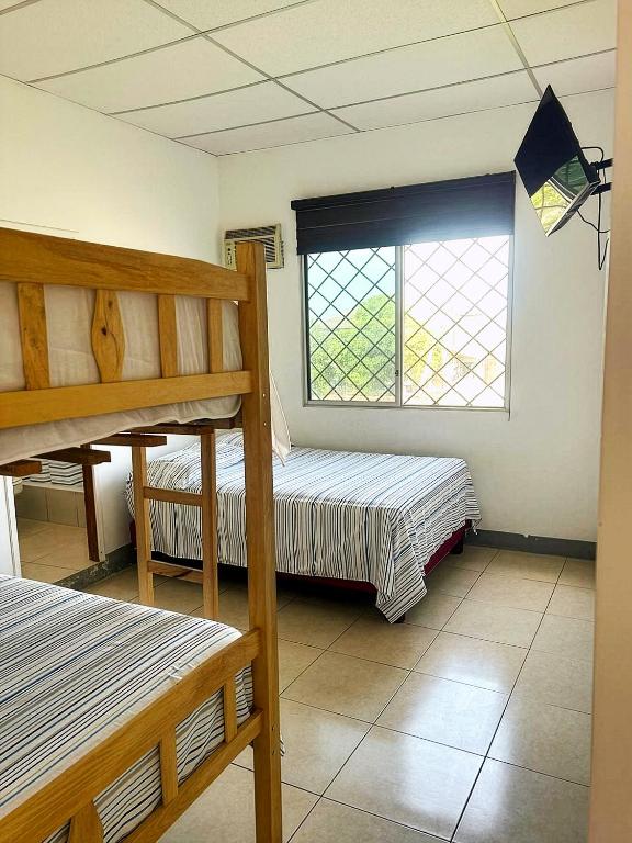 a bedroom with two bunk beds and a window at Caracola, habitación privada de Flor de Lis Beach House in Playas