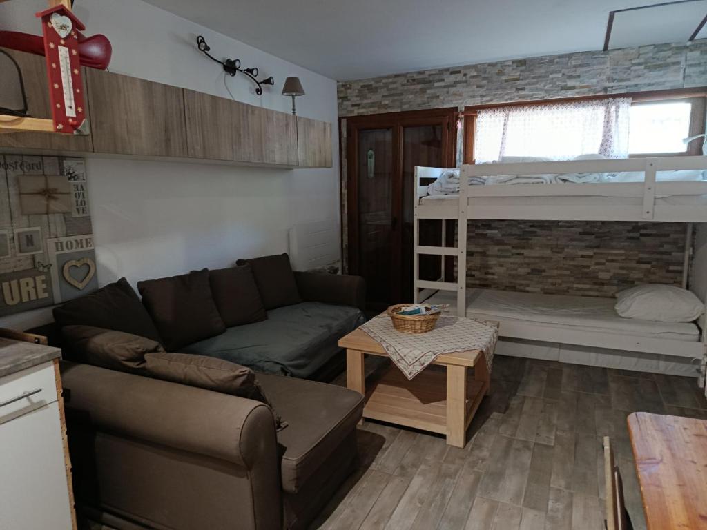 a living room with a couch and a bunk bed at Résidence le Schuss Studio Montagne en bas des pistes in Vars