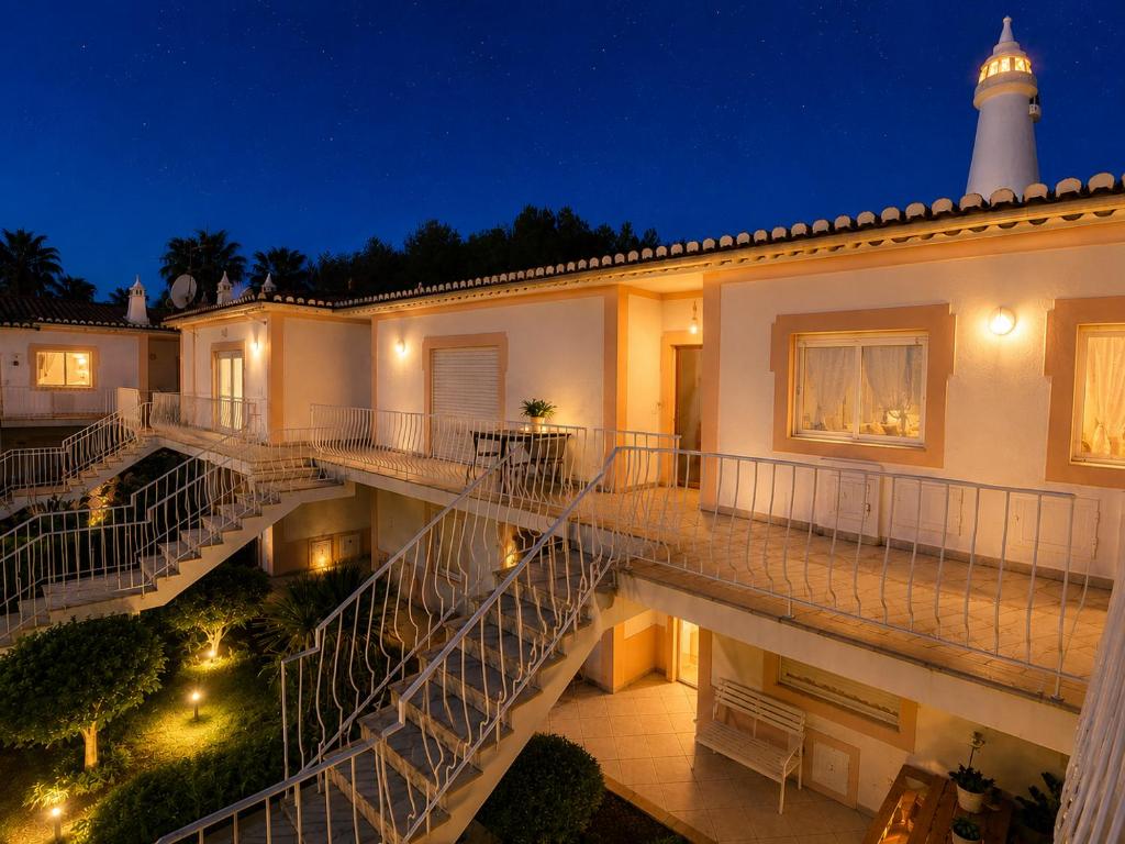 a building with stairs and a lighthouse at night at Apartamento Oásis Parque 2 in Portimão