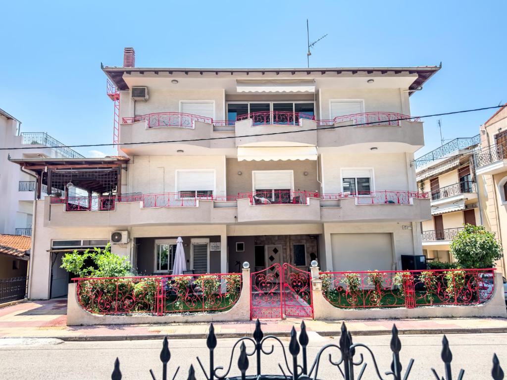 a large white building with red fence in front of it at Smile studio in Drama