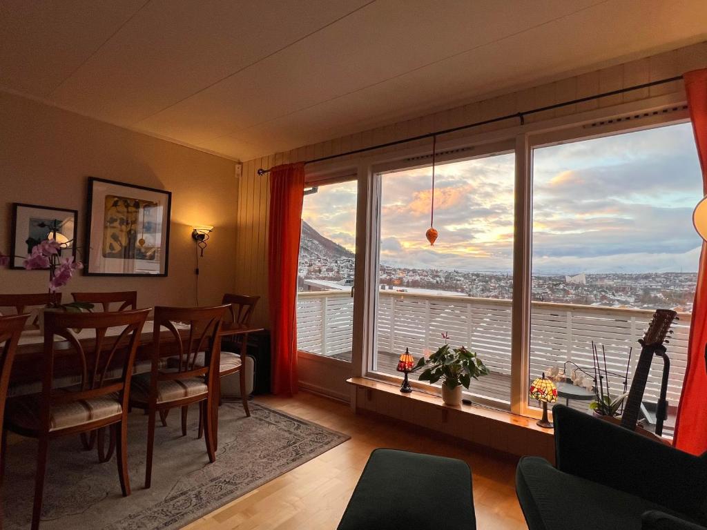 a dining room with a table and a large window at Venusvegen Skyline Views in Tromsø
