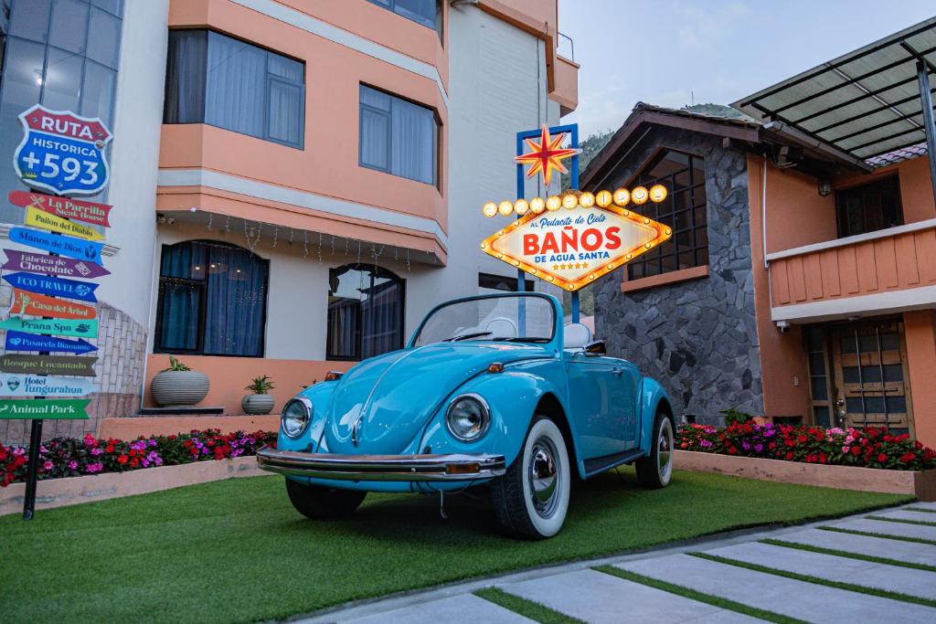 a blue car parked in front of a building with a sign at Casa Tungurahua in Baños