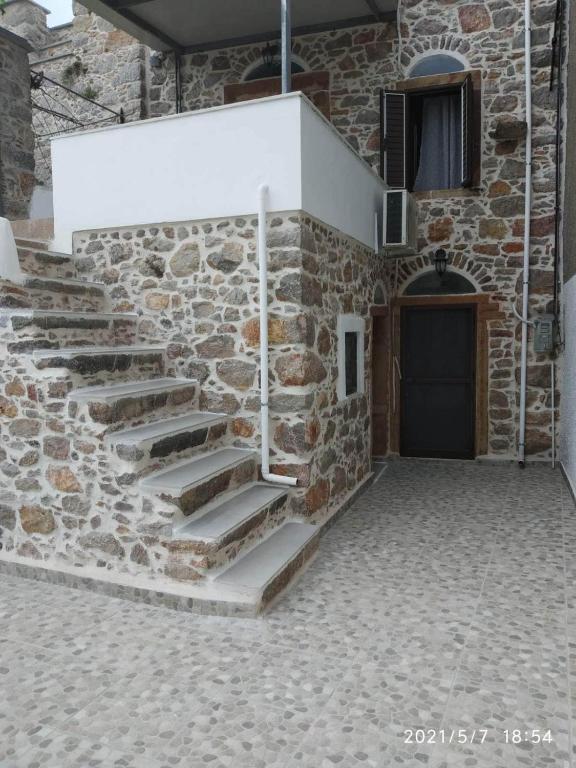 a stone wall with stairs in front of a door at Mastic lithos house in Chios