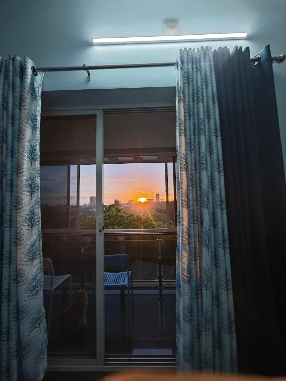 a room with a window with a view of the sunset at The Reset House Mangalore in Mangalore