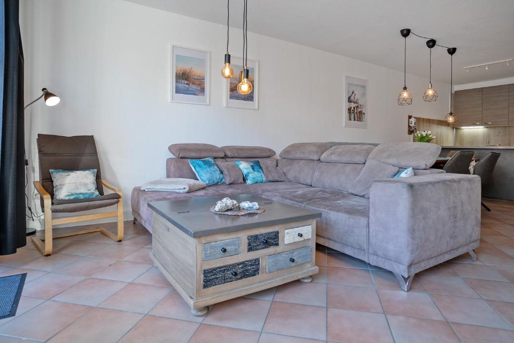 a living room with a couch and a chair at Haus Biene am Meer in Norden