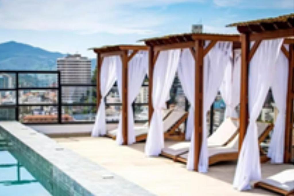 a row of white drapes on a roof at Flats Diamond - Conforto, ed.novo e moderno localização impar in São Lourenço