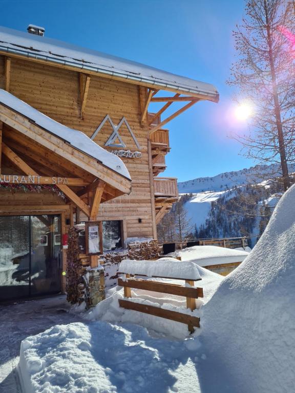 a log cabin with snow on the ground at Chalet Marano Restaurant & Spa in Isola 2000