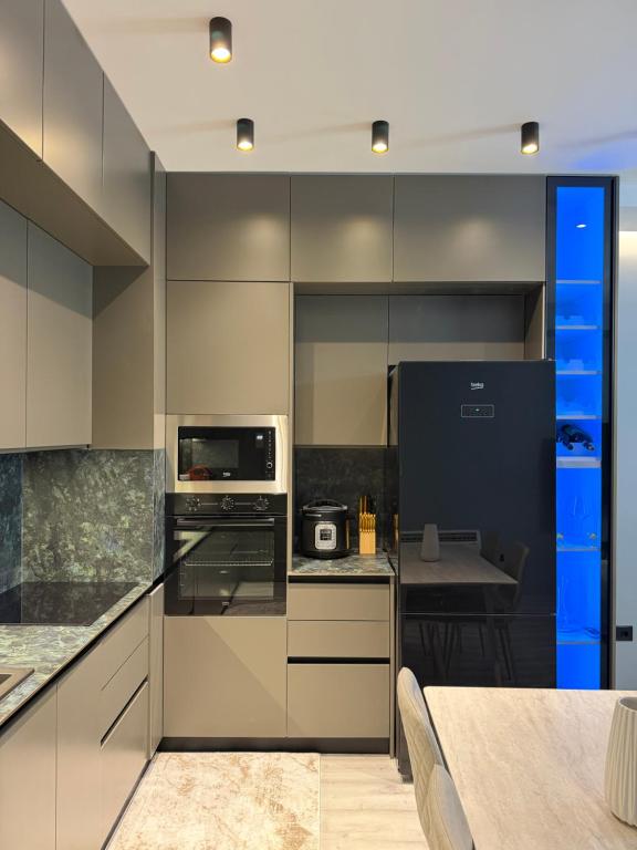 a kitchen with stainless steel appliances and a table at family-haven in Tirana