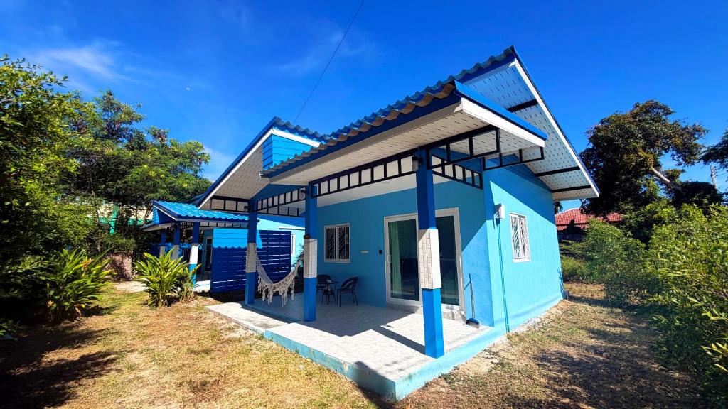 a blue house with a sign in front of it at Temple Light in Ko Phangan