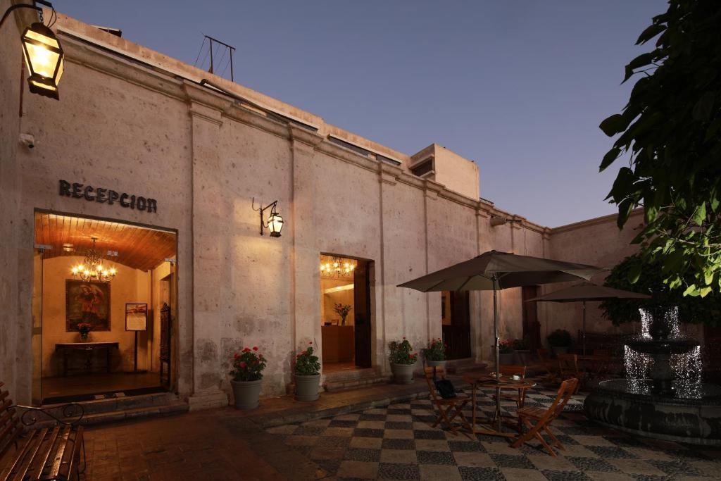 a building with tables and chairs and an umbrella at San Agustin Posada del Monasterio in Arequipa