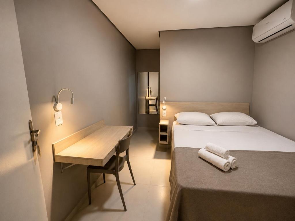 a bedroom with a bed and a desk and a table at Smart Hotel Aeroporto by Bsb Inn in Brasília
