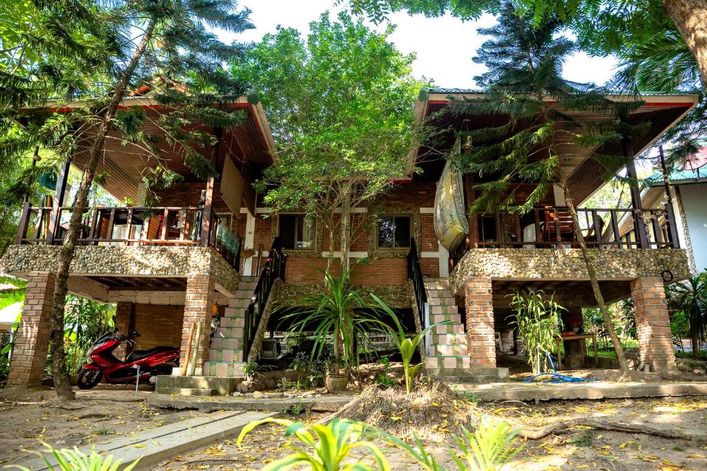 a house with a motorcycle parked in front of it at Zen Forest in Ko Phangan