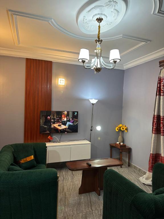 a living room with a couch and a tv at Fokam Hôtel in Nkongoa
