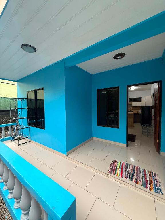 a room with a blue wall and white chairs at House Puerto Viejo in Puerto Viejo