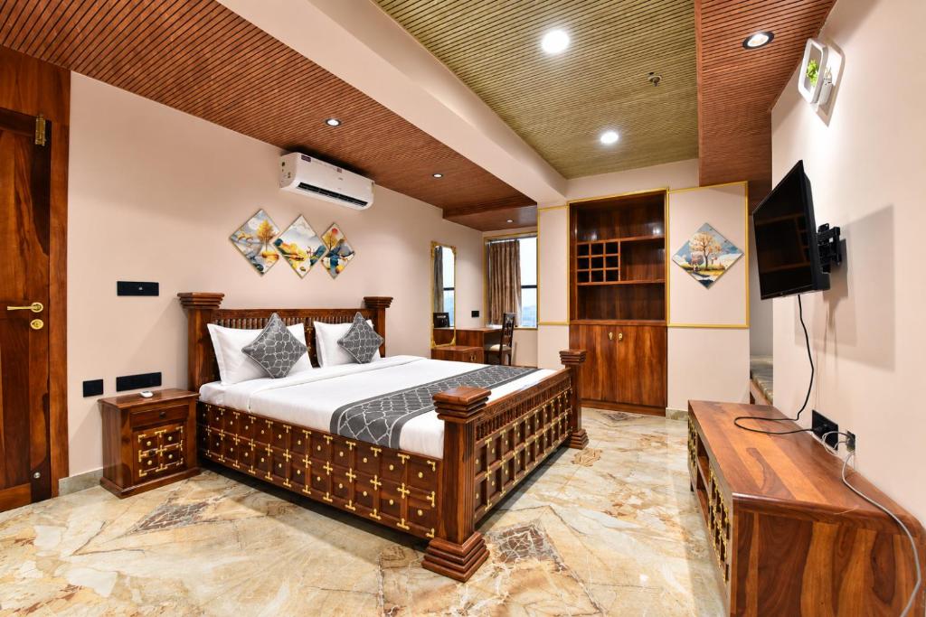 a bedroom with a bed and a flat screen tv at Luxora Suites in Jaipur