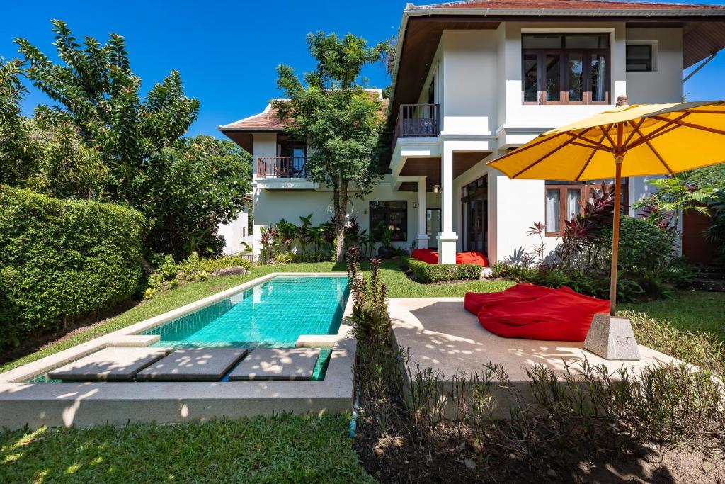 a house with a swimming pool and an umbrella at NB Villa Lilawadee in Chaweng Noi Beach