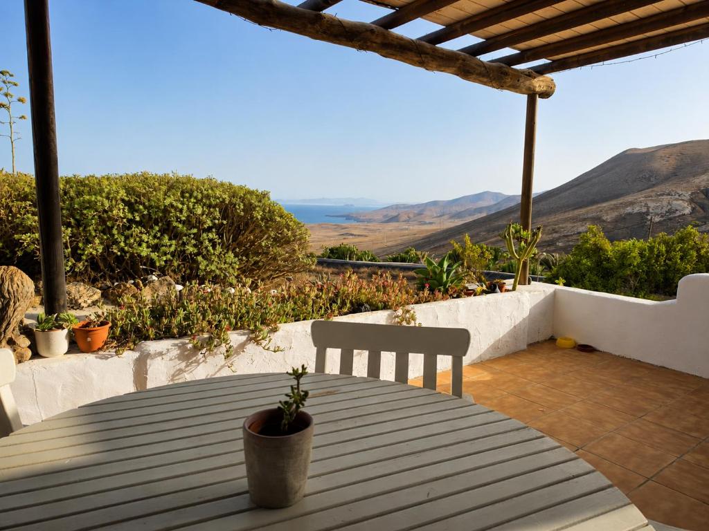 a table with chairs and a view of the ocean at Tabaiba Suites Lanzarote - Macaronesia Homes in La Asomada