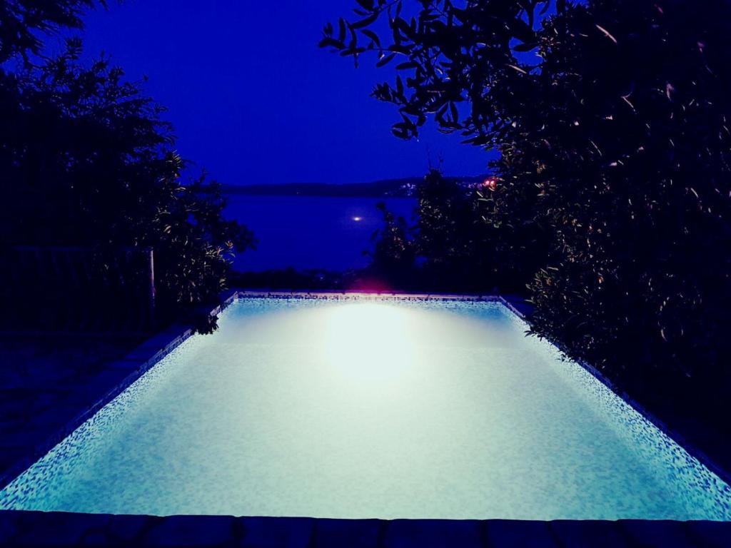 a swimming pool lit up at night at Apartments Marta in Trogir