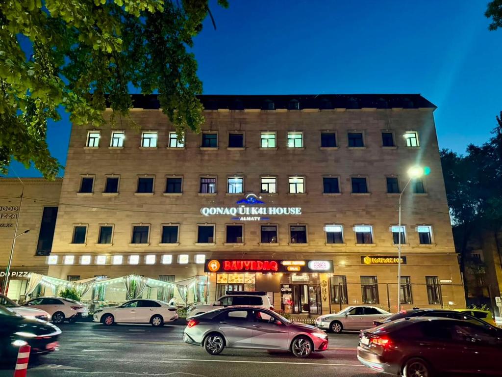 a building with cars parked in a parking lot at K41House in Almaty