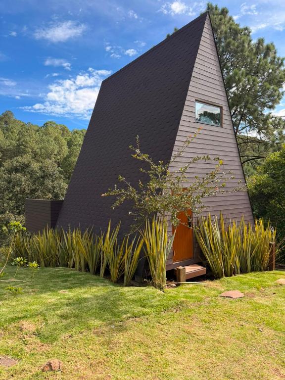 a small house with a gambrel roof at La Estela NatureSuite in Mazamitla