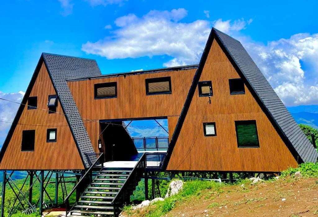 a large wooden house with stairs in front of it at Mravaldzali twins in Oni