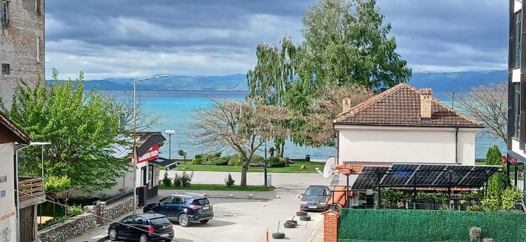 a street with cars parked in a parking lot next to the water at Apartments Matjan with private garages in Ohrid
