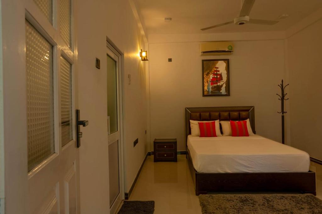 a bedroom with a bed with red pillows at My Home Guest in Polonnaruwa