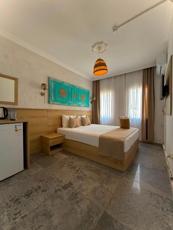 a bedroom with a large bed and a refrigerator at Bodrum Merkez Pansiyon in Bodrum City